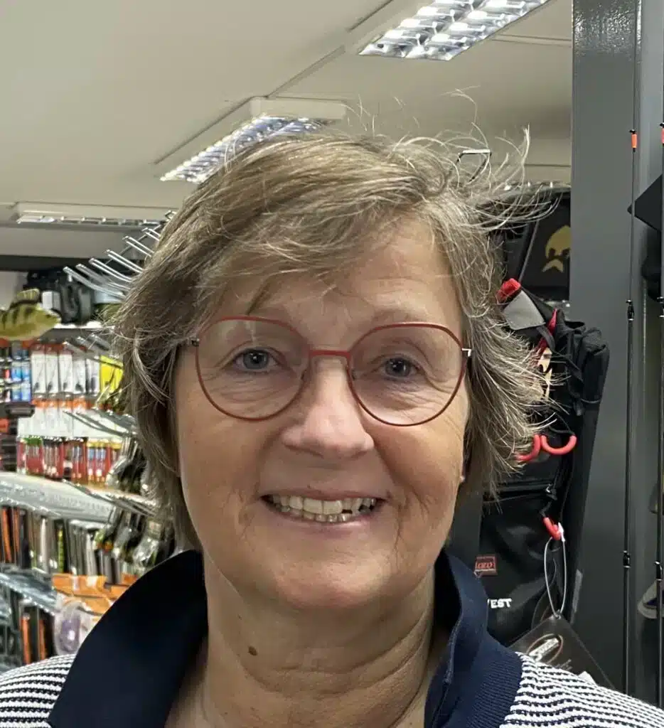 Smiling woman with red glasses in store
